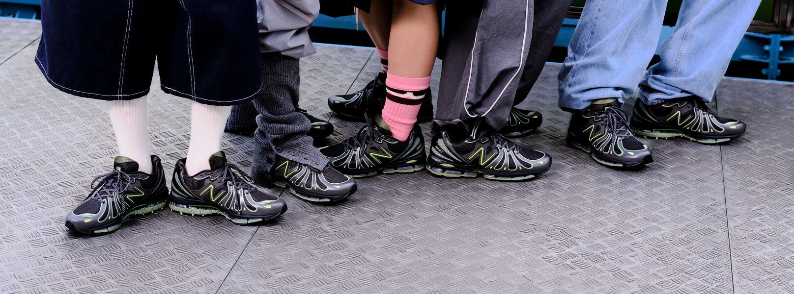 Off figure shot of a pair of lime green and black shoes on concrete with circles.